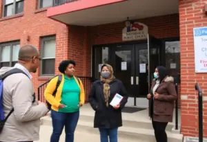 Community members discussing local issues in front of a Baltimore school.
